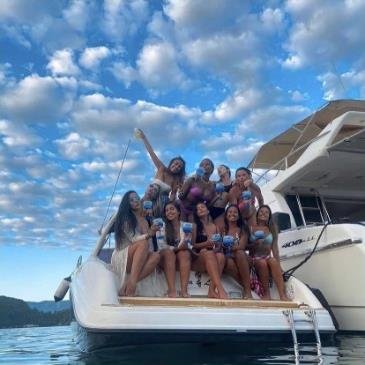 Grupo celebrando junto a um iate em Angra